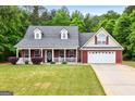 Charming single Gathering home, manicured lawn, inviting front porch, brick facade, and attached garage at 563 Deadwood Trl, Locust Grove, GA 30248