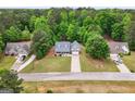 Aerial view of a home nestled amongst lush trees with neighboring homes nearby at 563 Deadwood Trl, Locust Grove, GA 30248