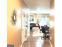 Hallway with hardwood floors, leading to the living room with a fireplace and sliding glass door at 3311 Thornbridge Dr, Powder Springs, GA 30127