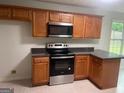 Modern kitchen with stainless steel appliances, ample cabinet space, and dark countertops at 127 Jenny Rd, Grantville, GA 30220