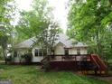 View of the home's rear, with a spacious wooden deck perfect for outdoor entertaining at 25 Lake Charles Ct, Covington, GA 30016