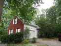 A red-brick home with an attached garage, featuring white trim, a driveway, and manicured bushes at 25 Lake Charles Ct, Covington, GA 30016