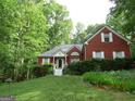 Charming brick home nestled among trees with a well-maintained front yard and inviting entrance at 25 Lake Charles Ct, Covington, GA 30016