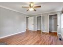 Spacious main bedroom with wood-look flooring, a ceiling fan, and two large closets at 72 S Bethany Rd, Mcdonough, GA 30252
