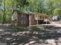 Exterior view of the property with brick, siding, mature trees and two car garage at 4081 Jodeco Rd, Stockbridge, GA 30281