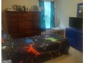 Bedroom with a black and blue video game themed bed and a large dresser for storage at 6153 Oakley Rd, Union City, GA 30291