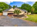 Well-maintained home features a garage, palm trees, and nice landscaping at 26 Cannongate Rd, Sharpsburg, GA 30277