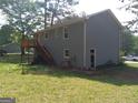 View of backyard of home with deck and stairs, blue siding, and green grass at 4616 Hamlet Se Walk, Conyers, GA 30094