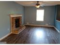 Cozy living room with a brick fireplace, ceiling fan, and hardwood floors at 4616 Hamlet Se Walk, Conyers, GA 30094