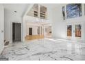 Bright and spacious living room with marble floors and a vaulted ceiling, leading to an outdoor deck at 1620 Saddle Ridge Way, Sandy Springs, GA 30350