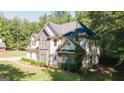 Well-maintained two-story home showcasing stone and siding, plus lush green landscaping at 1231 Hillview Rd, Hampton, GA 30228