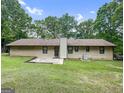 A spacious backyard features a concrete patio and lush lawn framed by mature trees at 110 Thompson Blvd, Stockbridge, GA 30281