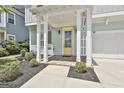 Inviting front porch with brick floor, white columns, and a bright yellow front door at 307 Owenberg Trce, Peachtree City, GA 30269