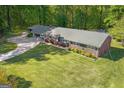 Aerial view of a brick ranch home with an expansive, green front lawn and mature trees at 118 Duvall Dr, Stockbridge, GA 30281