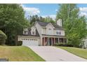 Two-story home with siding, brick accents, mature trees, and an attached two-car garage at 179 Parkside Dr, Stockbridge, GA 30281