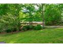 Well-kept home featuring brick facade, covered porch, attached garage, and surrounded by mature trees at 215 Ridge Rd, Tyrone, GA 30290