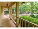 Inviting covered porch with wooden railings, offering a view of the tree-lined street and front yard at 215 Ridge Rd, Tyrone, GA 30290