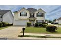 Attractive two-story home featuring a well-manicured lawn, attached garage, and tidy landscaping at 1130 Ivey Ln, Mcdonough, GA 30253