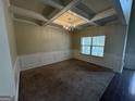 Dining room featuring a coffered ceiling, elegant chandelier, wainscoting, and hardwood flooring at 960 Spanish Moss Trl, Loganville, GA 30052