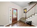 Inviting foyer with hardwood floors, staircase, and decorative front door with leaded glass at 542 Creek Stone Ln, Stone Mountain, GA 30087