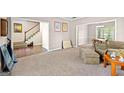 Open-concept space with plush carpeting, neutral paint, transitioning into a dining room with hardwood floors at 542 Creek Stone Ln, Stone Mountain, GA 30087
