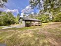 The back of this painted brick home features a wooden deck and a spacious yard surrounded by mature trees at 15 Laurie Ln, Covington, GA 30016