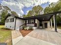 This home has a covered entrance, painted brick, well-manicured landscaping, and a long, modern driveway at 15 Laurie Ln, Covington, GA 30016