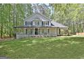Charming two-story home boasts a full front porch and mature landscaping at 110 Greenridge Ct, Fayetteville, GA 30215