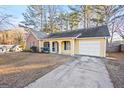 A delightful yellow home featuring a front porch and a convenient attached garage at 812 Bartow Ct, Riverdale, GA 30274