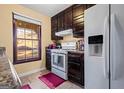 The kitchen features dark wood cabinets, white appliances and views of the neighborhood at 812 Bartow Ct, Riverdale, GA 30274
