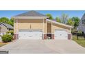 Three-car garage with white doors and spacious driveway at 140 Campaign Trl, Fayetteville, GA 30214