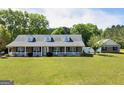 Charming brick home with a white picket fence, inviting porch, and well-manicured front lawn at 421 Hampton Rd, Fayetteville, GA 30215