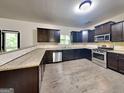 Modern kitchen with stainless steel appliances, granite countertops, and dark cabinetry at 143 Tara Blvd, Loganville, GA 30052
