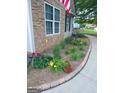 Beautifully landscaped garden bed with a variety of colorful flowers and decorative stonework along the walkway at 103 Fuller Ct, Grantville, GA 30220