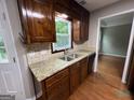 Kitchen view showcasing double sinks, granite countertops and wooden cabinets at 716 Wilkes Dr, Loganville, GA 30052