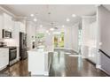 Open kitchen featuring white cabinets, a center island, stainless steel appliances and hardwood floors at 1106 Bakary Ct, Decatur, GA 30032