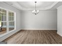 Bright living room featuring new wood floors, large windows, tray ceiling, and stylish chandelier at 3229 Broadnax Mill Rd # 4, Loganville, GA 30052