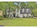 Charming white brick home with a well-manicured lawn and mature trees at 215 Calgary Dr., Peachtree City, GA 30269