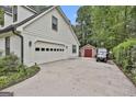 Spacious white garage with driveway, golf cart, and additional storage shed at 215 Calgary Dr., Peachtree City, GA 30269