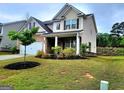 Beautifully landscaped front yard with a view of the two-story home, featuring a brick facade and well-maintained lawn at 542 Hinton Farm Way, Dacula, GA 30019