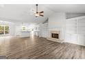 Open-concept living room with a fireplace, built-in shelving, and new flooring at 3219 Broadnax Mill Rd # 5, Loganville, GA 30052