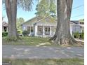 Charming bungalow framed by mature trees, showcasing its inviting front porch and well-kept lawn at 78 Atlanta Se Ave, Atlanta, GA 30315
