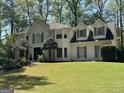 Stately painted brick home with manicured lawn and lush landscaping at 160 Hialeah Way, Roswell, GA 30075