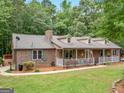 This brick home offers a long porch, and a well-kept lawn for outdoor enjoyment at 930 Singley Dr, Locust Grove, GA 30248