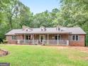 Lovely brick home with dormers, front porch, and landscaped front yard at 930 Singley Dr, Locust Grove, GA 30248