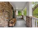 Inviting covered porch with a porch swing and stacked wood for the fireplace at 105 Riviera Ct, Fayetteville, GA 30215