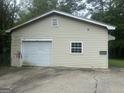 A detached garage with a roll-up door shows some wear, and is adjacent to the main home at 8833 Thomas Rd, Jonesboro, GA 30238