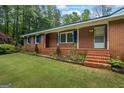 A quaint brick home features a well-maintained lawn and inviting entryway at 725 & 761 School Road, Hampton, GA 30228