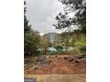 View of the pool surrounded by an iron fence and mature trees and landscaping at 374 Persimmon Dr, Sharpsburg, GA 30277