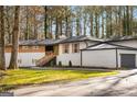 Charming front exterior with a driveway and well-maintained lawn, enveloped by mature trees at 2019 Emerald Dr, Jonesboro, GA 30236